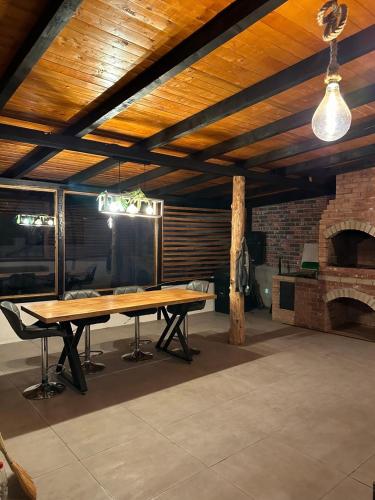 a large room with a table and a brick fireplace at Cabin&Villa Property in Târgu Ocna