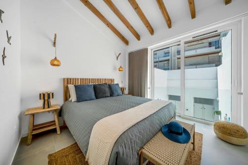 a bedroom with a bed and a large window at The Blue House - Mediterranean Loft in Faro