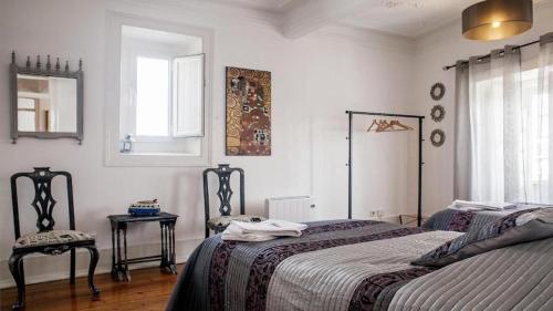a bedroom with a bed and a chair and a window at Find Me Inn Boutique Penthouse in Lisbon
