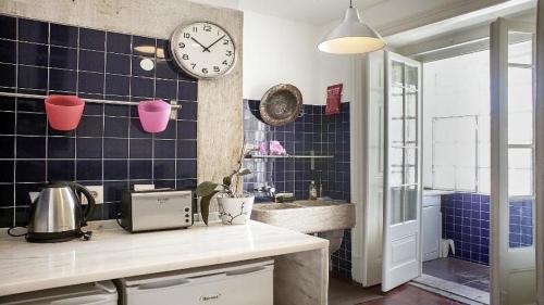 a kitchen with a sink and a clock on the wall at Find Me Inn Boutique Penthouse in Lisbon