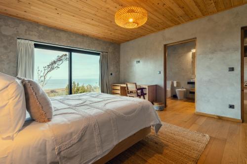 a bedroom with a bed and a large window at Casa do Alecrim in São Roque do Pico