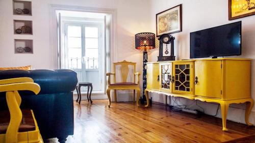 a living room with a blue couch and a television at Find Me Inn Boutique Penthouse in Lisbon