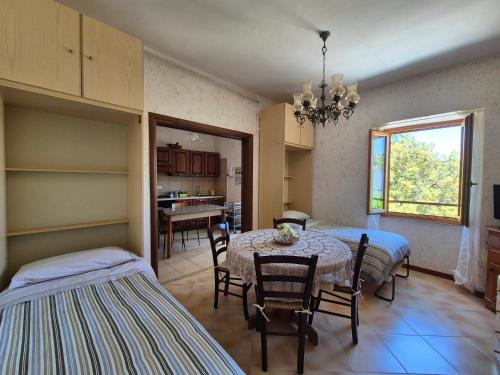 a room with two beds and a table and chairs at La Casa in Piazza in Toffia