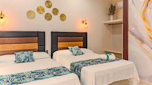 zwei Einzelbetten in einem Zimmer mit Spiegel in der Unterkunft Hotel San Miguel in Progreso