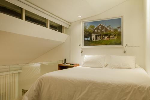 a bedroom with a white bed and a painting on the wall at The Grace Hotel in Bogotá