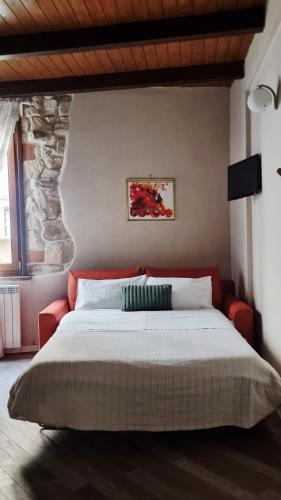 a bedroom with a large bed and a red couch at Le Contrade in Amelia