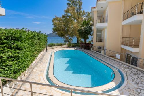 an apartment with a swimming pool in a building at Aura Seaside Apartment in Karavomylos