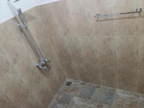 a bathroom with a shower with a tiled wall at Mirissa Cocoon in Mirissa