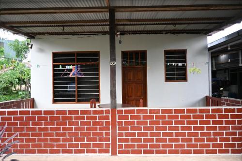 a house with a brick wall and a door at Depa en Pto Maldonado in Puerto Maldonado