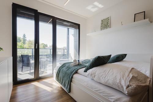 a bedroom with a bed and a sliding glass door at Premium Studio mit Balkon - Pfarrkirchen in Pfarrkirchen