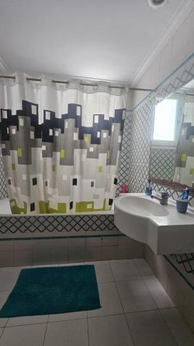 a bathroom with a sink and a shower curtain at Beau appt vue mer à gammarth in Gammarth