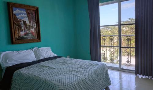 a bedroom with a bed and a large window at Henrietta Place B&B in Progreso