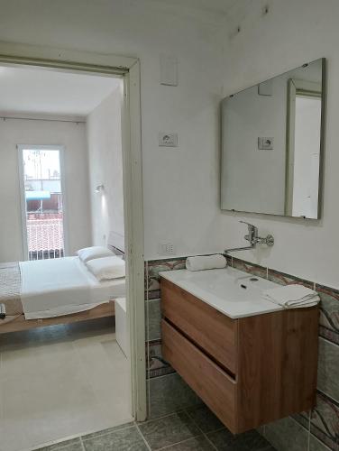 a bathroom with a sink and a mirror and a bed at Sea life Terrasini in Terrasini