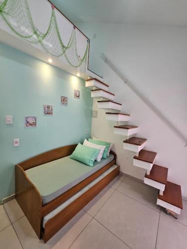 a bedroom with a bed under a staircase at Pousada Bahamas Sc in Penha