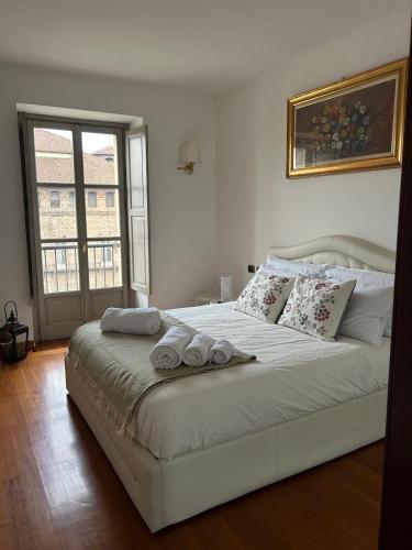 a white bed with two towels on it in a bedroom at Il re di Torino in Turin