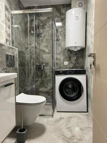 a bathroom with a washing machine and a toilet at Sabac City Apartman Centar S2 in Šabac