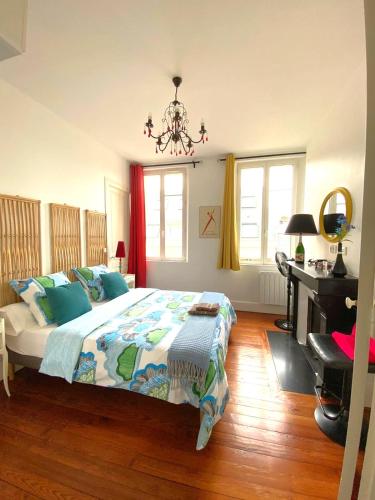 a bedroom with a bed and a desk in it at La Mignonette in Épernay