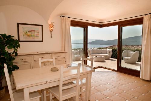 a living room with a table and chairs and a balcony at Le Ville Le Saline in Palau
