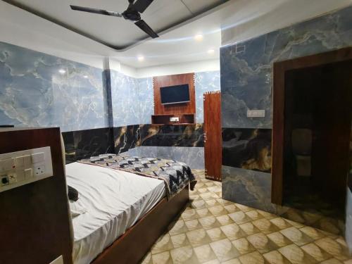 a bedroom with a bed and a blue wall at Tulsi Dham in Vrindāvan