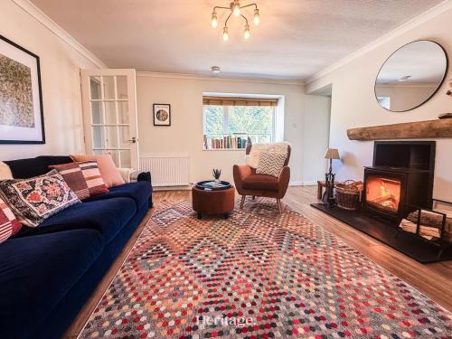 a living room with a blue couch and a fireplace at Nether Clashnoir, Glenlivet in Knockandhu