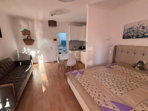 a bedroom with a bed and a couch and a table at Seaview Apartment Pinea Golem in Golem