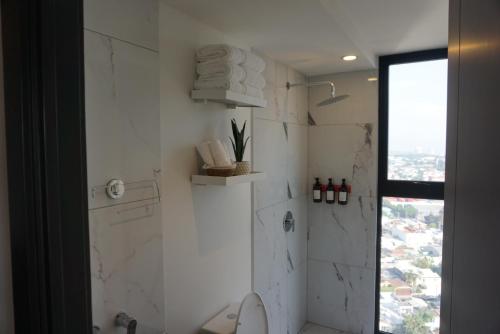a white bathroom with a shower and a toilet at Luxury Skyline Apartment with pool, city views & volcano views in El Rodeo