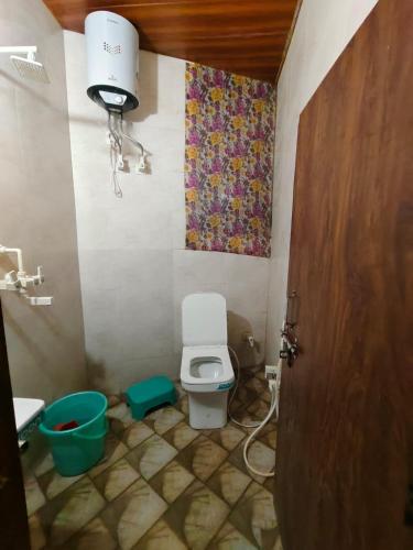 a small bathroom with a toilet and a sink at Tulsi Dham in Vrindāvan