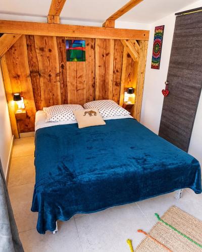 a bedroom with a bed with a blue blanket at Cocon-ardechesauvage in Pont-de-Labeaume