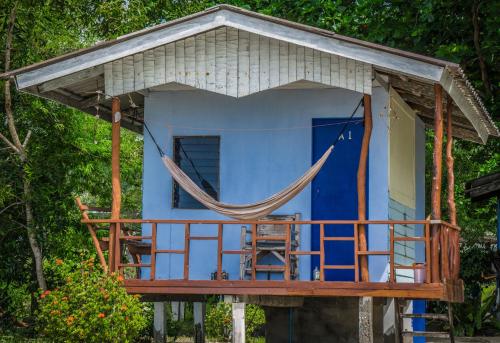 niebieski dom z hamakiem na tarasie w obiekcie Two Rocks Bungalows w mieście Baan Tai