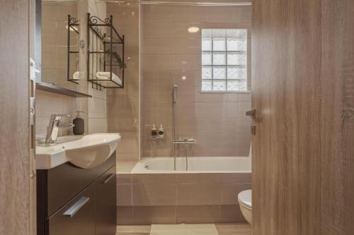 a bathroom with a tub and a sink and a toilet at Metsovo Fireplace Retreat 2 in Metsovo
