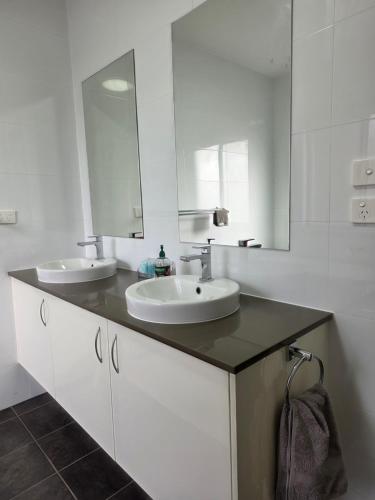 a bathroom with two sinks and a mirror at Quiet Homestay Ulladulla in Ulladulla