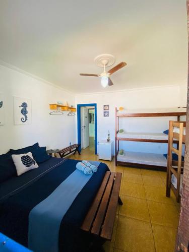 a bedroom with a blue bed and two bunk beds at Hostel dos Gring0s in Maricá