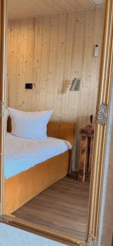 a mirror reflecting a bed in a room at HACIENDA & Królicza Nora in Zatory