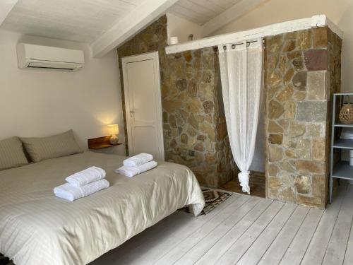 a bedroom with a bed with towels on it at Casa Collina - Grottino in Pisticci