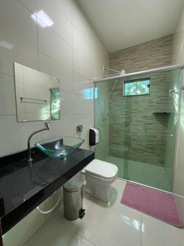 a bathroom with a glass sink and a toilet at Hotel Camping R Formoso in Bonito