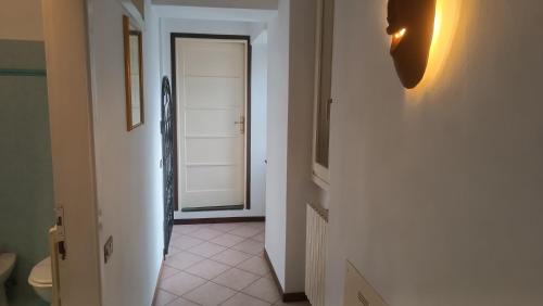 a hallway with a white door and a white tile floor at Oasi Panoramica Suite in Lecco