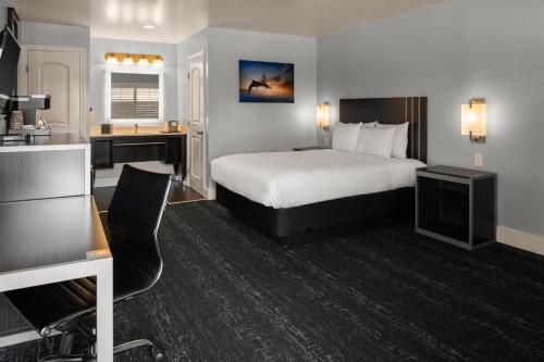 a hotel room with a bed and a desk at Pacific Inn Monterey in Monterey