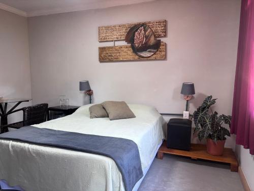 a bedroom with a bed and a picture on the wall at Recanto dos Querubins in Cambé