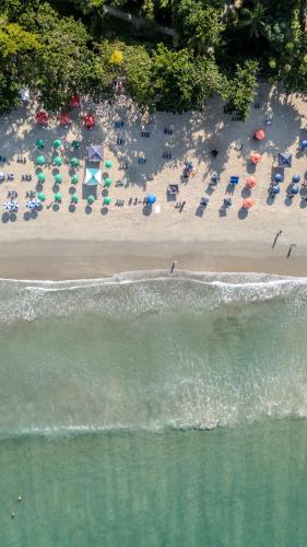 an aerial view of a beach with chairs and umbrellas at Pousada Barra do Sahy in Barra do Sahy