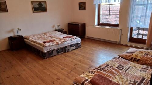 a bedroom with two beds and a wooden floor at Apartmán Andels I in Rakovník
