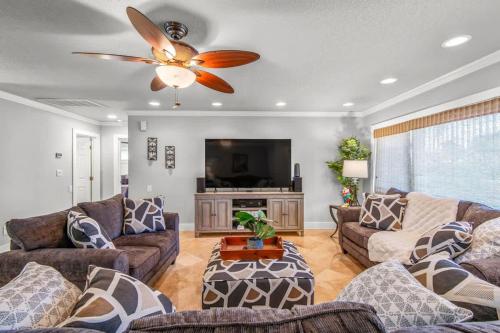 a living room with couches and a ceiling fan at Clearwater Calling in Clearwater Beach