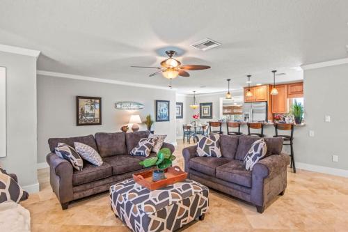 a living room with two couches and a kitchen at Clearwater Calling in Clearwater Beach