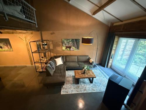 a living room with a couch and a table at 't Woldhoesie in Diever
