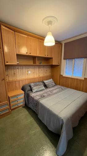 a bedroom with a large bed with wooden cabinets at Ana in Burela de Cabo