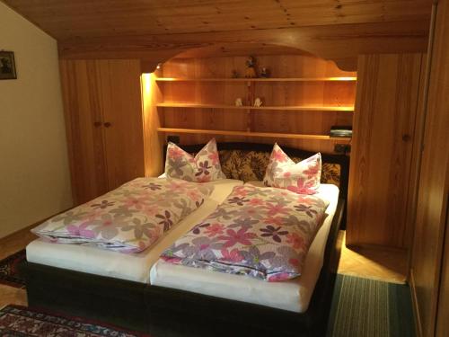 a bed with two pillows on it in a room at Apartements Ingrid Unhoch-Raggl in Oberammergau
