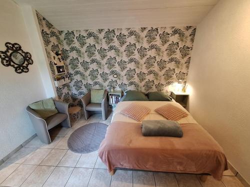 a bedroom with a bed and a chair at Studio 11, Draps, Linge, Wifi # Longère Bretonne#Morbihan in Sulniac