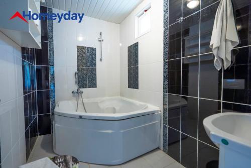 a white bathroom with a tub and a sink at Villa Mountain with Pool in Gedeller