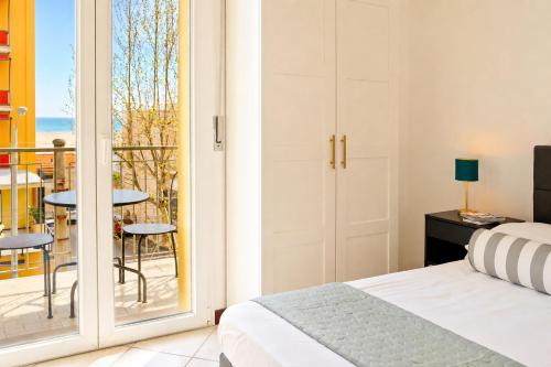 a bedroom with a bed and a balcony with a view at APPARTAMENTI LEONE - Vista Mare - Pet Friendly in Rimini