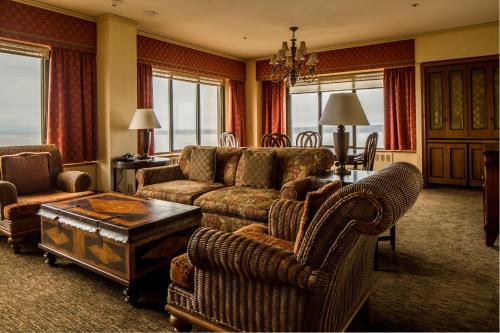 a living room filled with furniture and a fire place at The Hotel Captain Cook in Anchorage