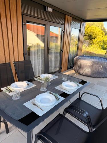 a dining table with two chairs and a tableasteryasteryasteryasteryasteryasteryastery at Mobile House Aurora with whirlpool in Ankaran